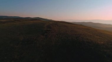 Kuru sarı otlardan oluşan hava sahası. Olkhon Adası 'ndaki Steppe. Baykal Gölü, Rusya. İnsansız hava aracı günbatımındaki tepeler