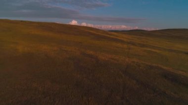 Kuru sarı otlardan oluşan hava sahası. Olkhon Adası 'ndaki Steppe. Baykal Gölü, Rusya. İnsansız hava aracı günbatımındaki tepeler