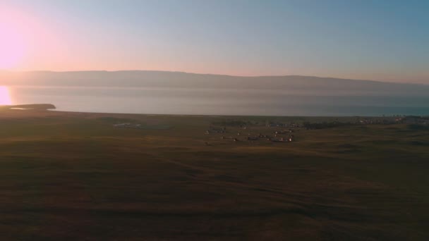 Campo aéreo de grama amarela seca. Estepe em Olkhon Island. Lago Baikal, Rússia. Colinas de imagens de drones ao pôr-do-sol — Vídeo de Stock