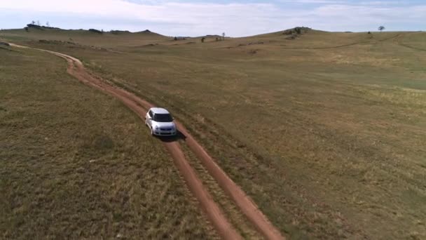 Aerial footage filmed with drone of pickup car riding in steppe. the car travels along the steppe to Siberia, roads laid along the Baikal island through the grassy hills. — Stock Video