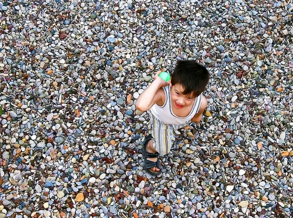 Little boy playing with a green ball at the beach — Stock Photo, Image