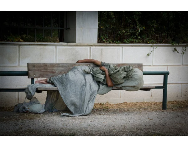 Homeless man is sleeping on a bench