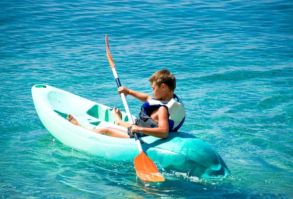 Chico se está divirtiendo, y disfrutar de la experiencia aventurera kayak en el mar —  Fotos de Stock