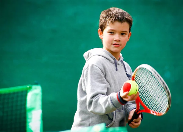 Yeşil arka plan bulanık üzerinde küçük tenis oyuncusu