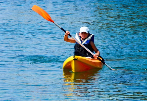 Leçons de kayak. Garçon avec costume de bouée de vie en cours de kayak — Photo