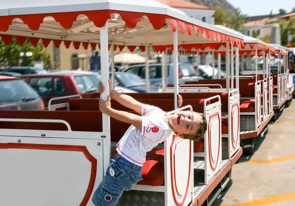 Happy boy playing and hanging on the side of sightseeing train — Stock Photo, Image