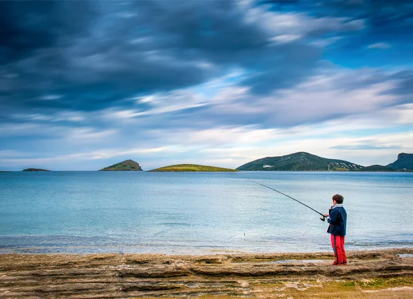 Pesca un día lluvioso bajo el cielo pesado con nubes dramáticas  . — Foto de Stock