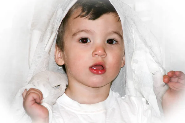 Retrato de un niño que se divierte con las cortinas blancas en su casa . —  Fotos de Stock