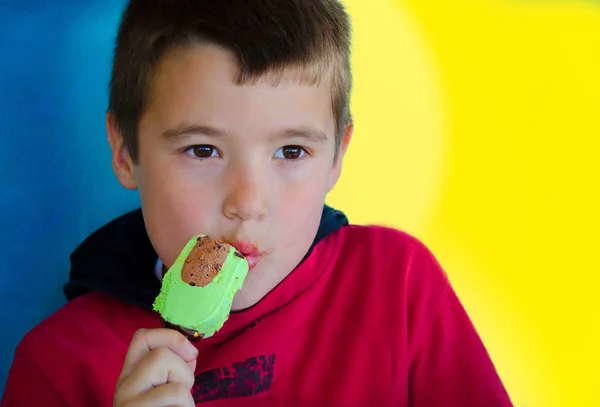 Niño en rojo disfrutar de helado de cacahuete y chocolate —  Fotos de Stock