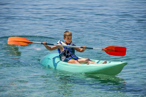 Lekce kajaku. Chlapec v plavkách na kajaku během letních prázdnin na řeckém ostrově. — Stock fotografie