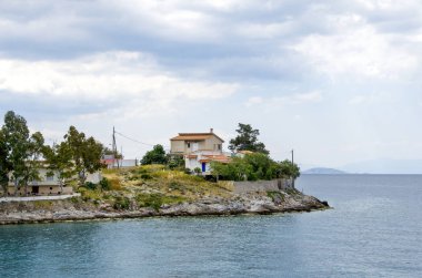 Pachi köyünün rüzgarlı ve dramatik bir gökyüzü altında manzarası. Yunanistan