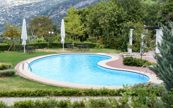 Bella piscina lussuosa con acque cristalline verdi in giardino — Foto Stock