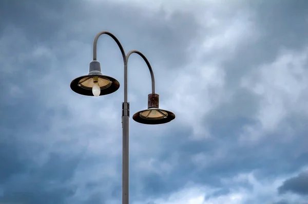 Pouliční lampy proti dramatické modré obloze — Stock fotografie