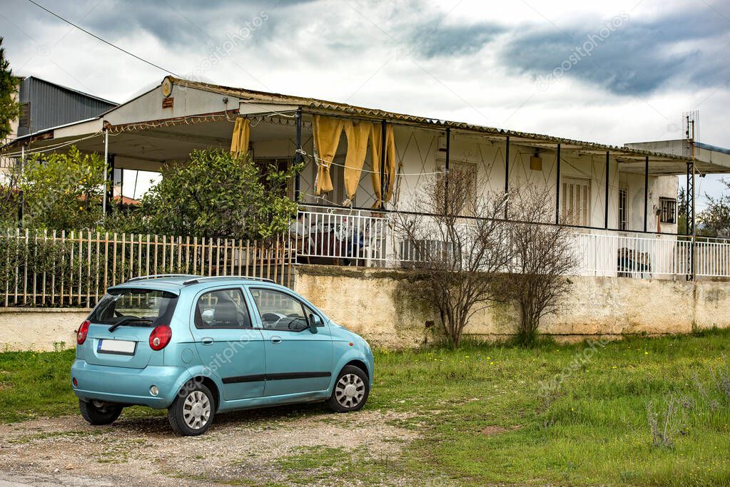 Old house and a small car parked outside