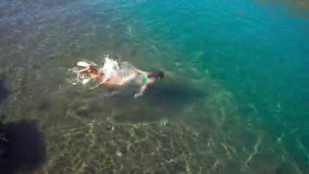 Mujer joven saltando al agua. Descanse en el océano — Vídeos de Stock