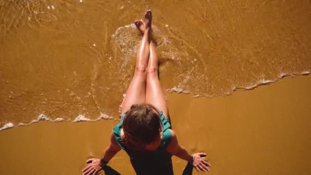 Mulher de cima sentado na costa com areia amarela . — Vídeo de Stock