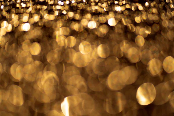 Jiskřivé světlo boke blur. Pozadí zlatých třpytivých částic. — Stock fotografie