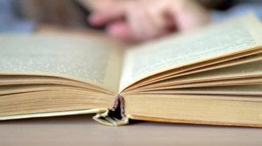 Masanın üzerinde yatan kitabın çarşafını çevir. Görüntüyü kapat.