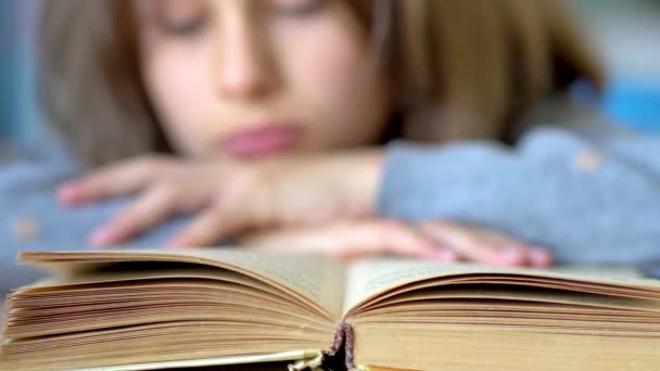 The child carefully reads the book. Close up view. — Αρχείο Βίντεο