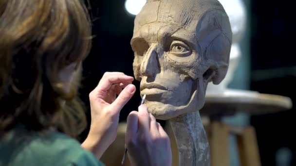 Скульптор на работе. Женщина, работающая у человеческой головы. — стоковое видео