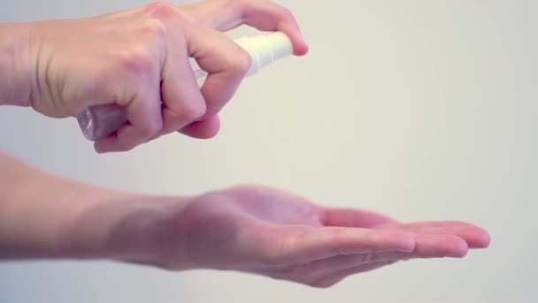 Рука женщины, применяющей дозатор дезинфицирующего средства для очистки от микробов, бактерий на белом фоне — стоковое видео