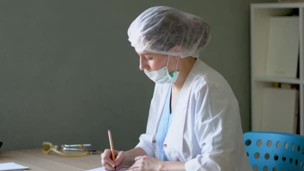Жінка-лікар працює за офісним столом — стокове відео