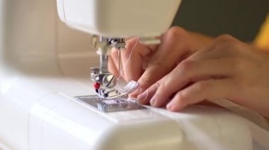 Perdelerin kenarlarını kapatma süreci. İğne düşüyor. Dikiş işlemi başlıyor. Görüntüyü kapat.