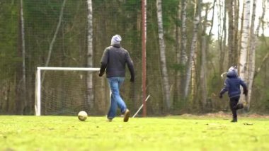 Covid-19 karantinası sırasında aile parkta futbol oynuyor..