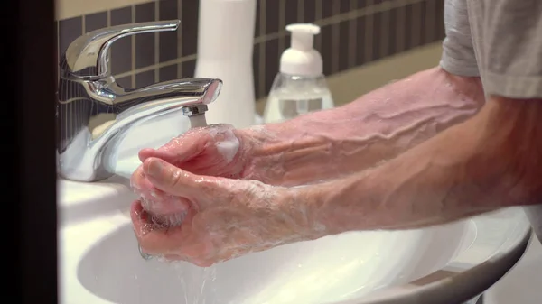 Concept of protecting the body from germs and viruses. Hand of old man that applying lather and soap