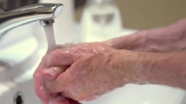 Vücudu mikroplardan ve virüslerden koruma kavramı. Sabun ve köpük uygulayan yaşlı adamın eli