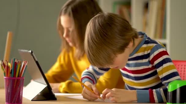 Leuke kinderen gebruiken laptop voor onderwijs, online studie, thuis studeren. Jongen en meisje hebben huiswerk op afstand leren. — Stockvideo