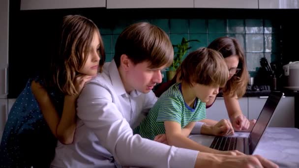 코로나 바이러스 격리 기간 동안 집에서 배우는 거리 Covid 19. 아버지는 아들 이 노트북을 만드는 것을 도와 준다. — 비디오
