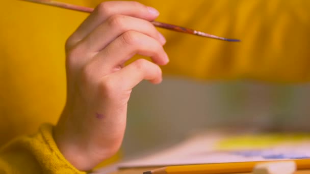 Educación a distancia de los niños en el hogar durante el período de cuarentena para covid19. Una colegiala realiza una tarea de dibujo creativo . — Vídeos de Stock