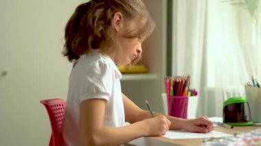 Tatlı çocuk eğitim için dizüstü bilgisayar kullanıyor, online öğrenim görüyor, evde eğitim görüyor. Kızın ev ödevi var..