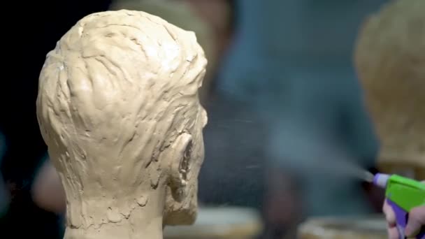 En kvinnlig skulptör i arbete på en skulptur av ett mänskligt huvud. — Stockvideo