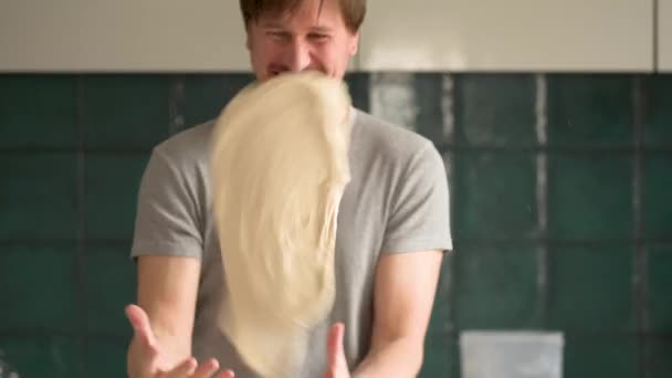 Prepering ingredients for pizza. Funny man having fun with dough. He is trying to throw pizza dough — Stock Video