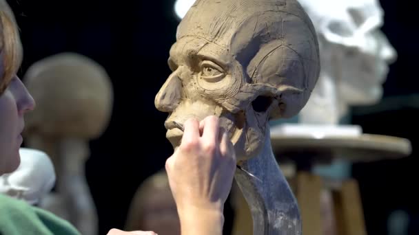 Donna scultrice al lavoro su una scultura di una testa umana. — Video Stock