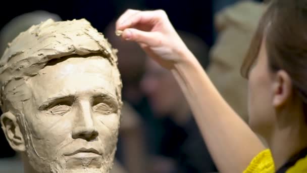 Kvinna skulptör i arbete på en skulptur av ett mänskligt huvud. — Stockvideo