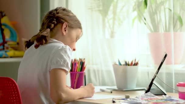 O portátil bonito do uso da criança para a instrução, estudo em linha, casa que estuda. Menina tem dever de casa na escola em casa. — Vídeo de Stock