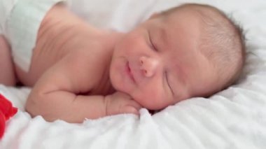 Tatlı küçük bebek uyuyor ve rüyasında esniyor.