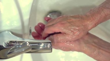 Vücudu mikroplardan ve virüslerden koruma kavramı. Sabun ve köpük uygulayan yaşlı adamın eli