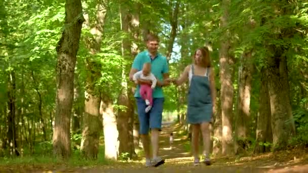 Mamma, papà e bambino passeggiano nel parco. — Video Stock