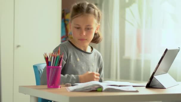 O portátil bonito do uso da criança para a instrução, estudo em linha, casa que estuda. Menina tem dever de casa na escola em casa. — Vídeo de Stock