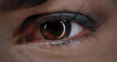 Close up of a woman's eye with beautiful make up, opening in a studio lighting. Slow motion. BMPCC 4K
