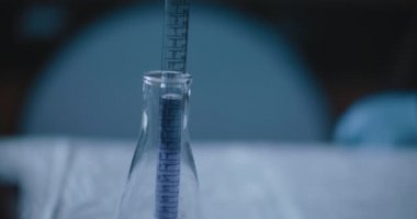 Bilim adamı, laboratuardaki reaksiyonları test etmek için konik bir şişeye mor bir sıvı koydu. Yakın çekim, el kamerası, ağır çekim, izleme, Bmpcc 4K ile çekim. Kavram: Bilim, kimya
