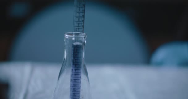 科学者たちは 実験室で反応のための化学物質をテストするために 紫色の液体を円錐フラスコに入れました Bmpcc 4Kで撮影された閉鎖 ハンドヘルド スローモーション — ストック動画