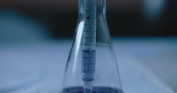 研究室で反応のための化学物質をテストするために円錐フラスコから紫色の液体を取り出す科学者 Bmpcc 4Kで撮影された閉鎖 ハンドヘルド スローモーション — ストック動画