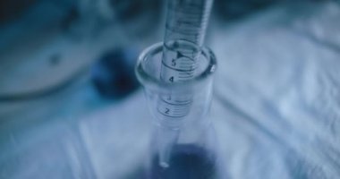 Konik bir şişeden çıkarılan mor sıvının yakın çekim görüntüsü. Yakın çekim, yavaş çekim, takip çekimi, el kamerası. Bmpcc 4K ile vurulmuş. Kavram: Bilim, kimya