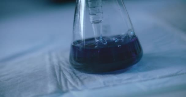 在实验室进行的化学实验中 从锥形瓶中的刻度吸盘中冒出气泡 近距离 慢动作 用Bmpcc 4K射击 — 图库视频影像