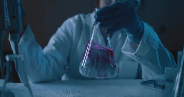 Wissenschaftlerin Die Einem Dunklen Laborraum Eine Konische Flasche Mit Blauer — Stockvideo